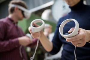 Eine Person hält zwei ringförmige Controller in den Händen