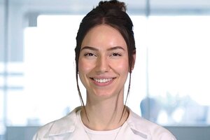 Die Porträtaufnahme zeigt Julia Viktoria Wesolowski in einem Labor mit weißem Kittel