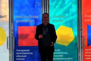 Mann steht vor bodentiefen Glasfenster, die mit bunten Folien beklebt sind