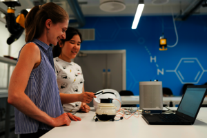 Zwei weiblich gelesene Personen experimentieren in einem Labor.