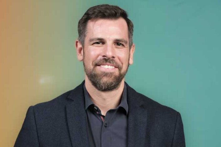 Mann in Anzug, hält einen Blumenstrauß in der Hand