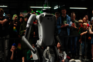 Ein Humanoider Roboter steht umringt von Menschen zur Schau.