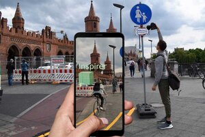 Auf dem Handy-Kamerabild ist ein 3D-Modell eines geplanten Bauwerks eingeblendet.