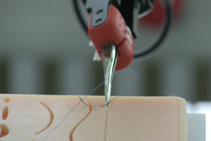 An einem Roboterarm befestigte Nadel näht eine Spalte in einer Silikonoberfläche zusammen