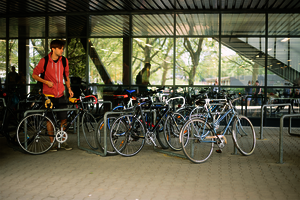 Ein BHT-Student schließt sein Fahrrad vor Haus Bauwesen an.