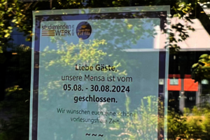 An einer Glastür hängt ein Informationsblatt zu den Schließzeiten der BHT-Mensa vom 5. bis 30. August.