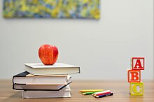 Red Apple Fruit on four pile Books