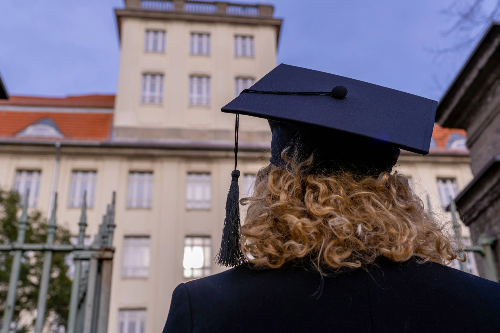 Rückenansicht einer Frau mit Doktorhut vor Haus Beuth der BHT