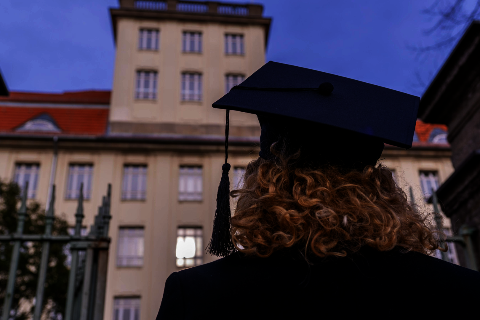 Rückenansicht einer Frau mit Doktorhut vor Haus Beuth der BHT