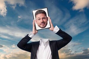 Ein Mann ohne Kopf hält ein Tablet hoch, in dem ein Bild seines Kopfes angezeigt wird