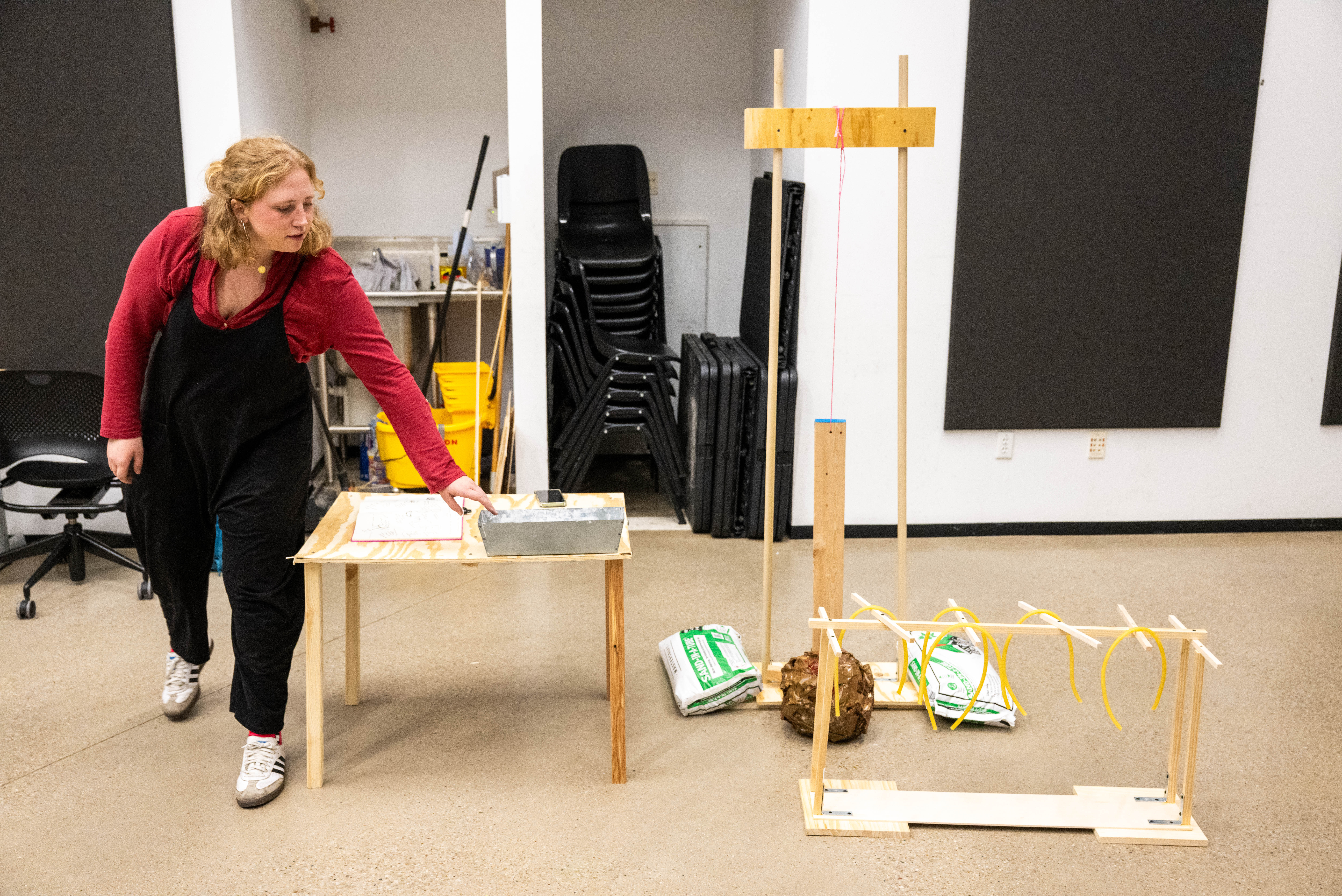 Frau mit einer Installation aus Holzlatten und weiteren Elementen