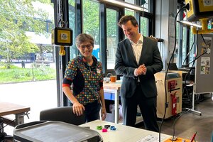 Eine Frau und ein Mann stehen vor einem Tisch mit technische Geräte und Materialen