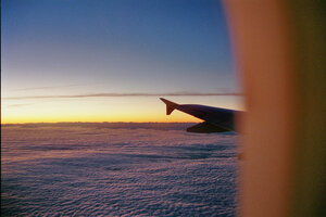Hinterer Teil eines Flugzeugs vor Sonnenuntergang über dem Meer