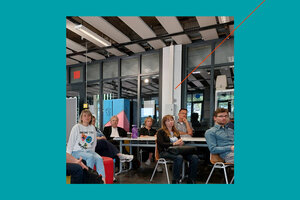 Gruppe von Menschen sitzt in einem Raum vor einer Fensterfront