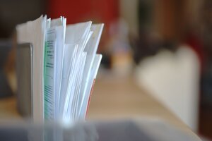 Eine Briefablage mit geschlossenen Briefumschlägen, Dokumenten und Papieren.