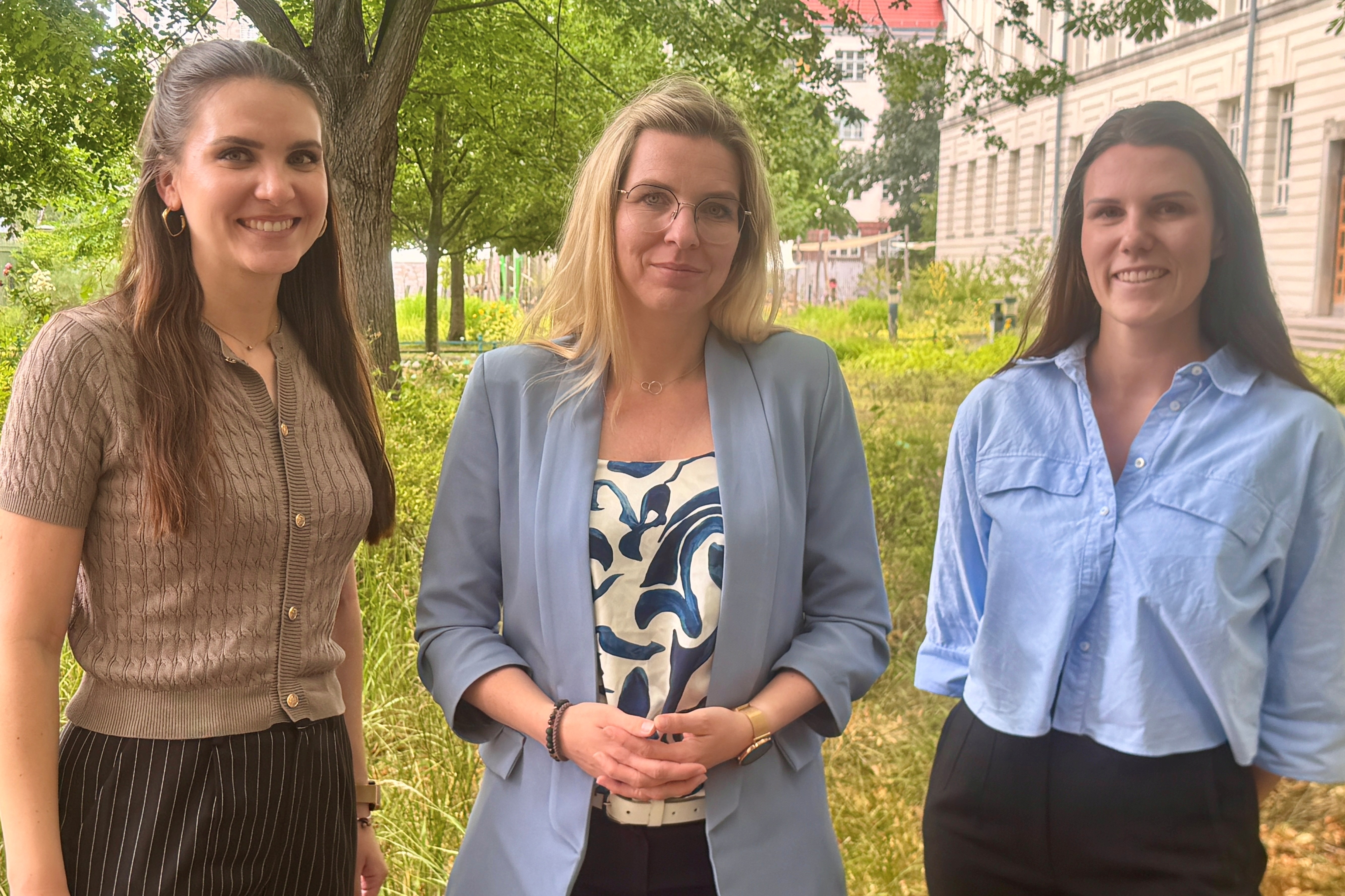Drei Frauen stehen nebeneinander im grünen Vorgarten des BHT-Präsidiums