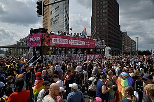 Demonstrationszug in der Innenstadt von Berlin: Eine Person schwenkt eine Regenbogenflagge, ein Bus trägt die Aufschrift „Liebe tut der Seele gut“