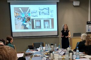 Eine Studentin erzählt einer Gruppe von Menschen über ihre Erfahrungen während eines Forschungspraktikums