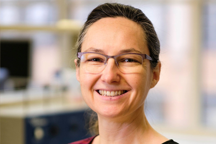Portraitbild einer Frau mit Bille und zurückgebundenen Haaren.