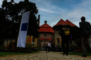 Menschen gehen zu einem Altbau-Kuppelgebäude.