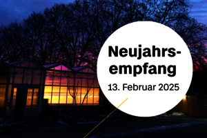 Erleuchtetes Gewächshaus der BHT vor rötlichem Himmel bei Sonnenaufgang