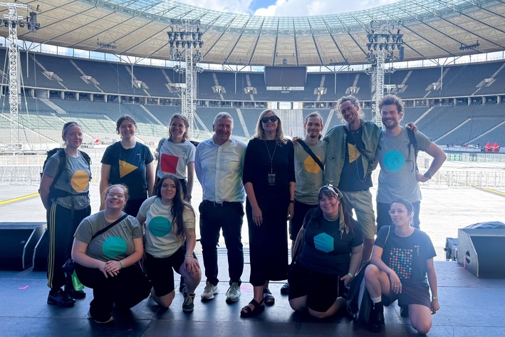 Gruppenfoto von 12 Personen auf der Bühne des Berliner Olympiastadions