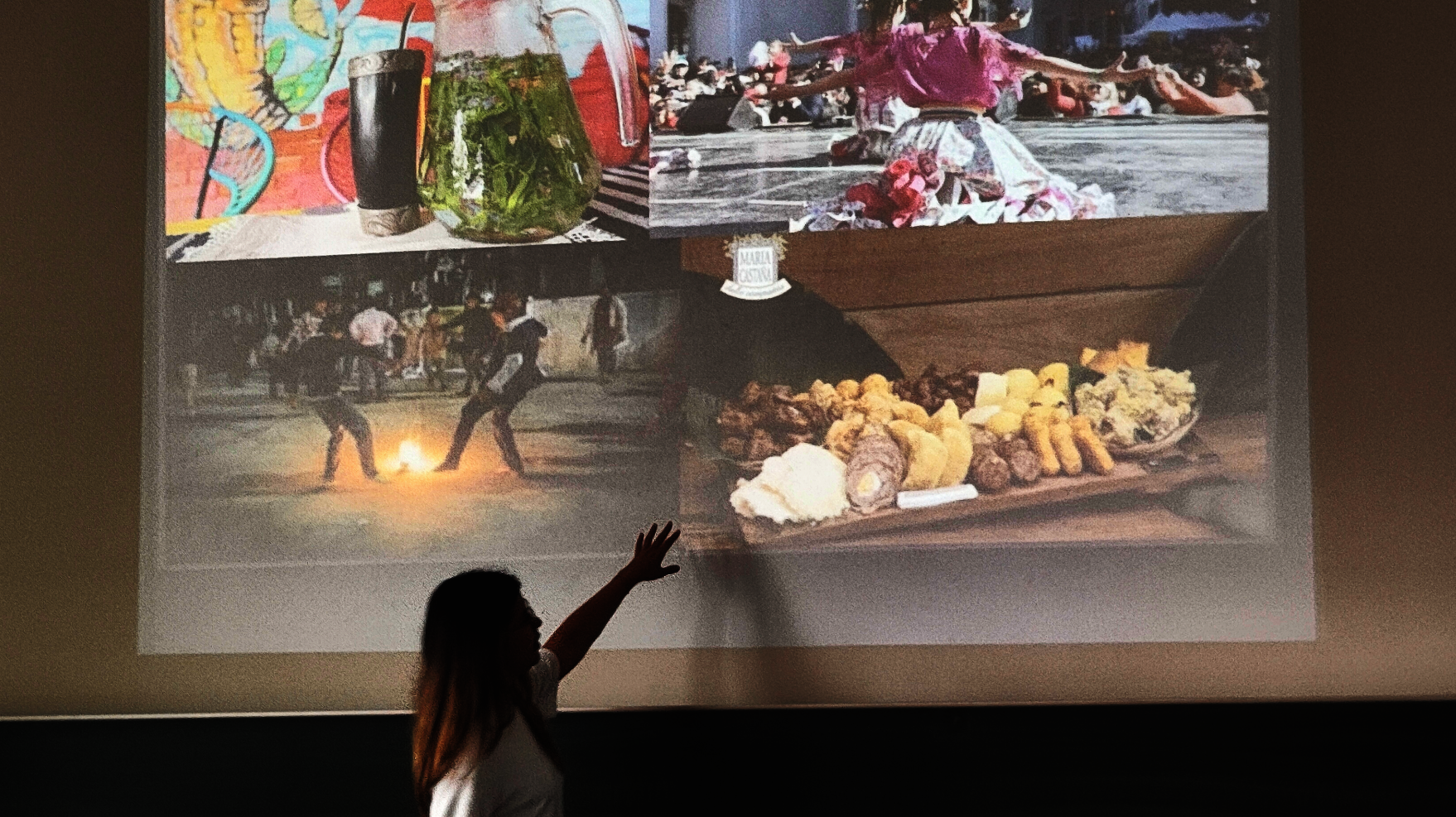 Frau zeigt auf eine Projektion mit Bildern von Eindrücken einer Reise