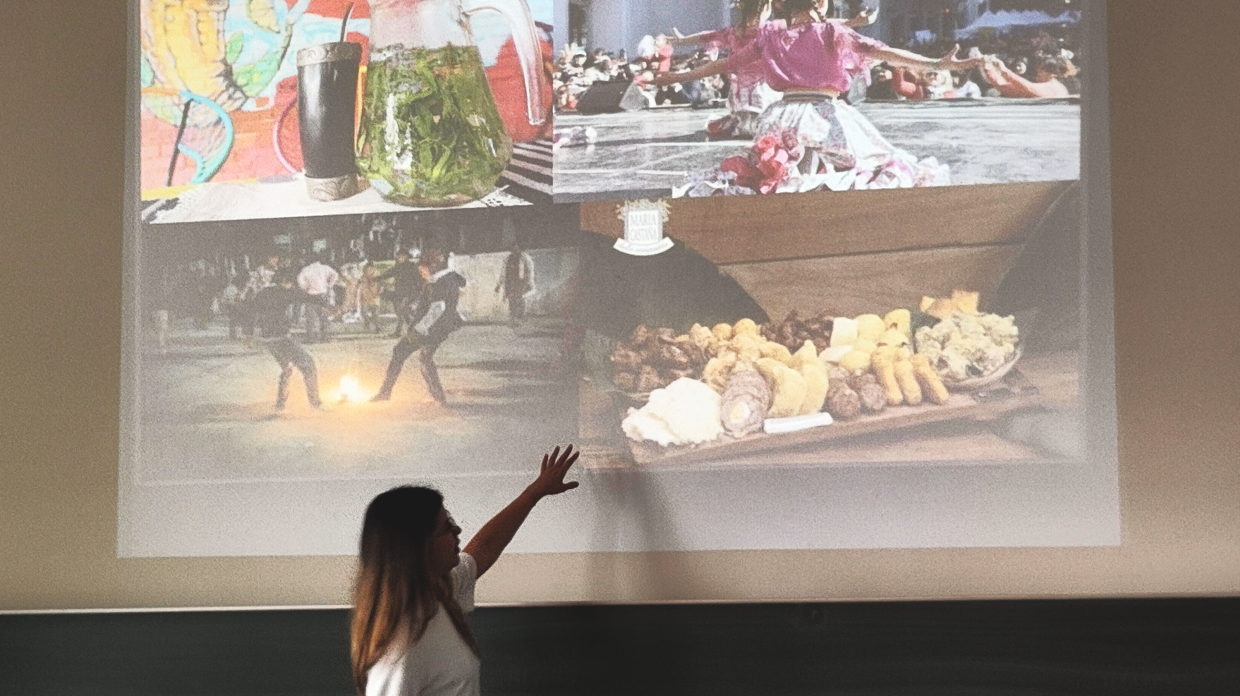 Frau zeigt auf eine Projektion mit Bildern von Eindrücken einer Reise