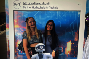 Zwei Schülerinnen posieren vor einer Fotowand