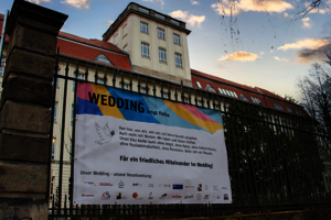 Eines der bunten Banner von „Wedding zeigt Farbe“ vor Haus Beuth der BHT.