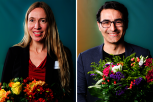 Eine Frau und ein Mann in feierlicher Kleidung mit Blumensträußen in den Händen.