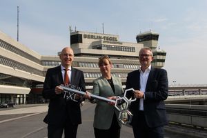 Schlüsselübergabe in Tegel: Gudrun Sack, Philipp Bouteiller und Werner Ullmann mit dem symbolischen Schlüssel vor dem ehemaligen Flughafen