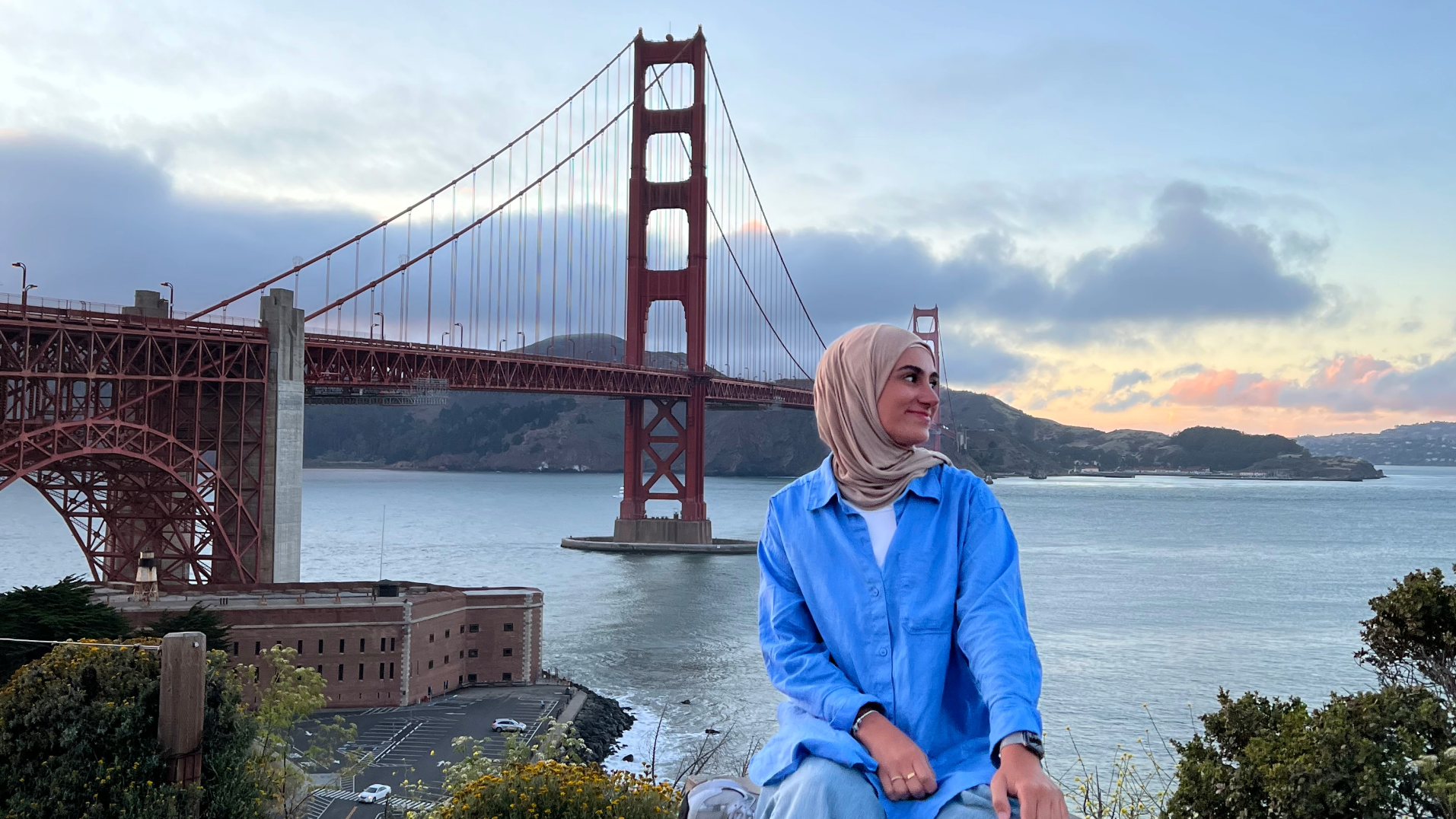 Eine Frau sitzt vor der Golden Gate Bridge