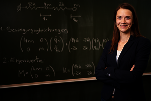 Prof. Dr. Katharina Höhne steht vor einer Tafel mit mathematischen Formeln.