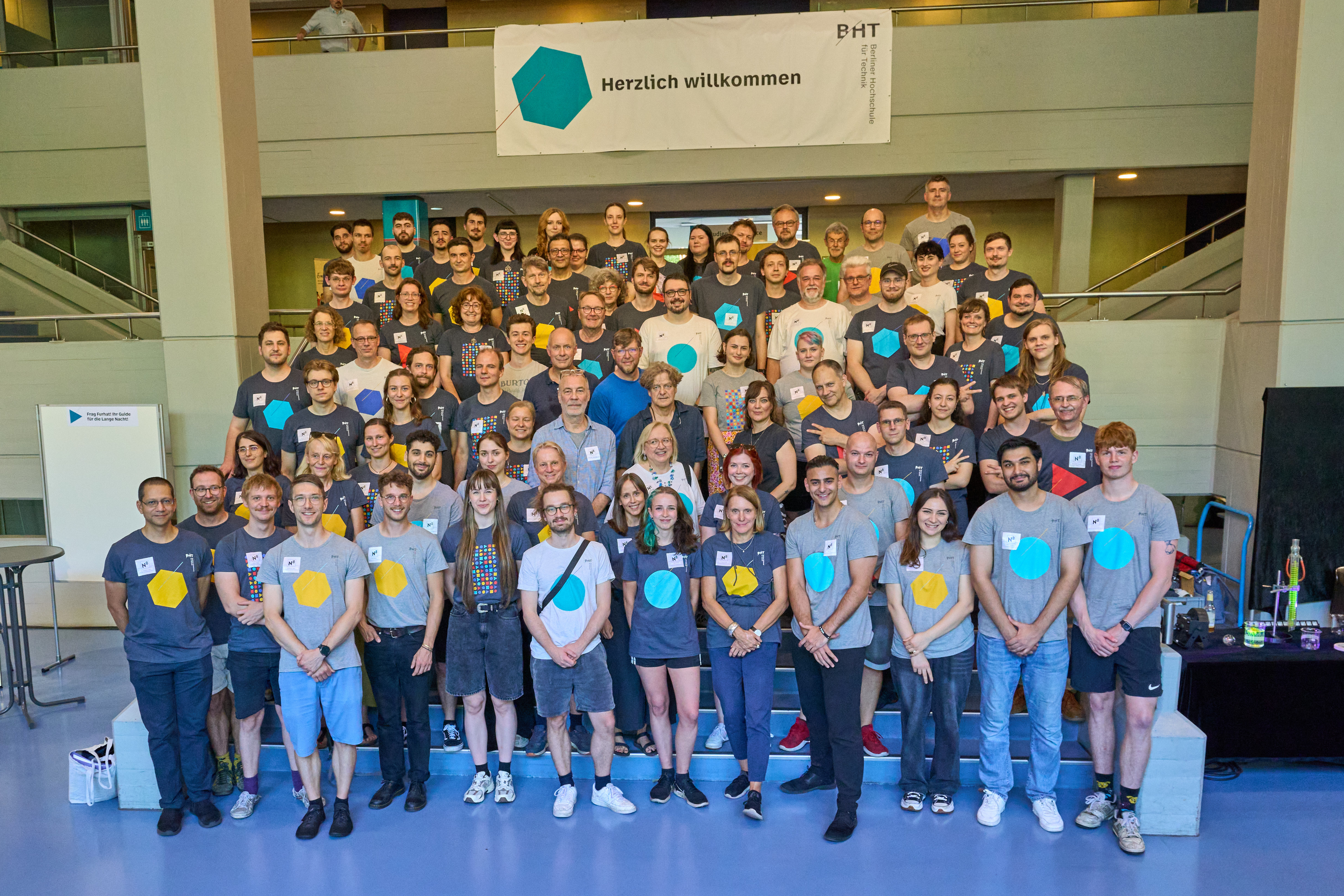 Großes Gruppenfoto von den Mitarbeiter*innen der BHT auf einer Treppe.