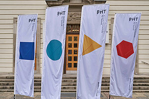 Flaggen mit Logo der BHT vor dem Eingang des Hauses Beuth auf dem BHT-Campus