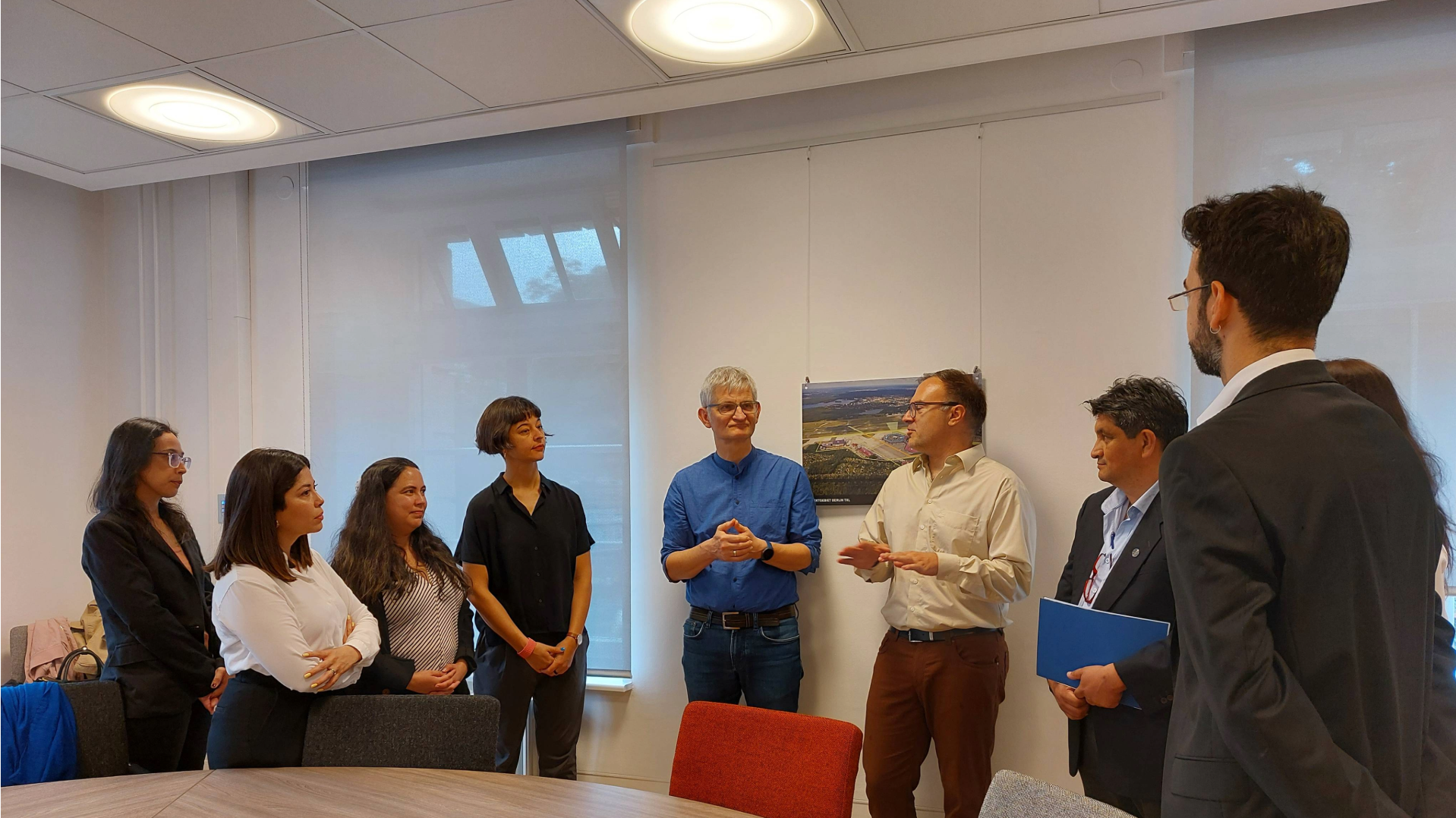 Eine Gruppe von Menschen steht an einem großen Tisch zusammen