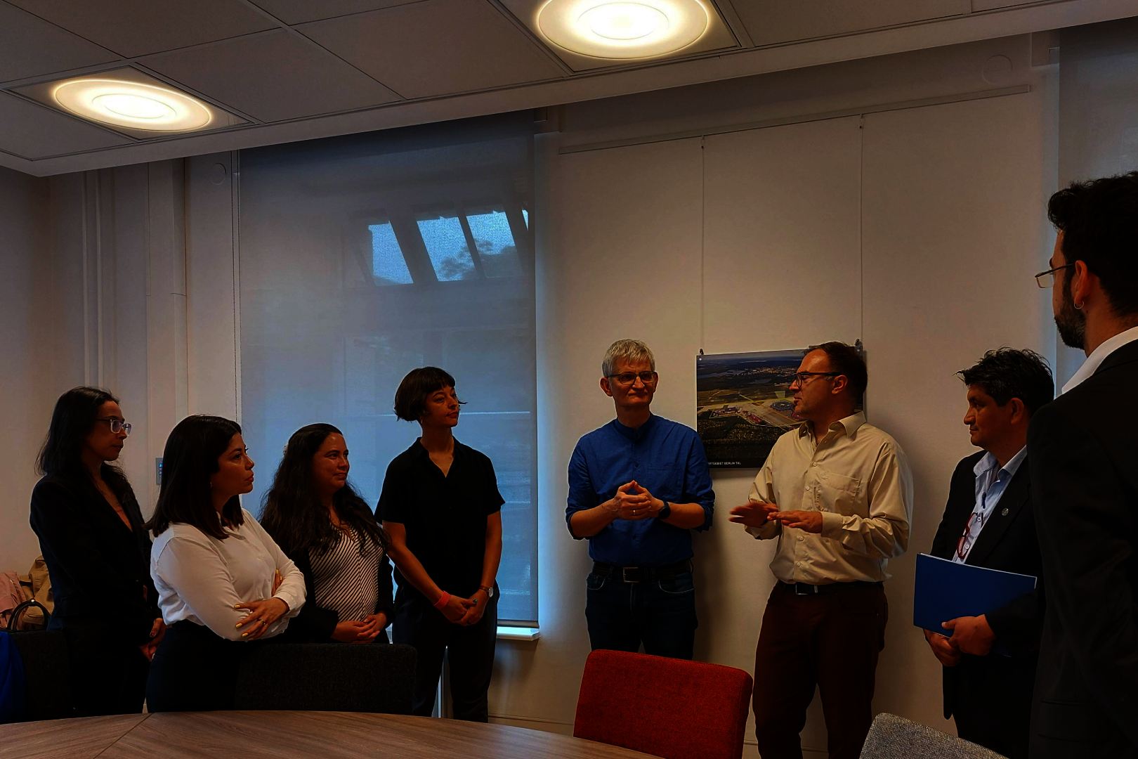 Eine Gruppe von Menschen steht an einem großen Tisch zusammen