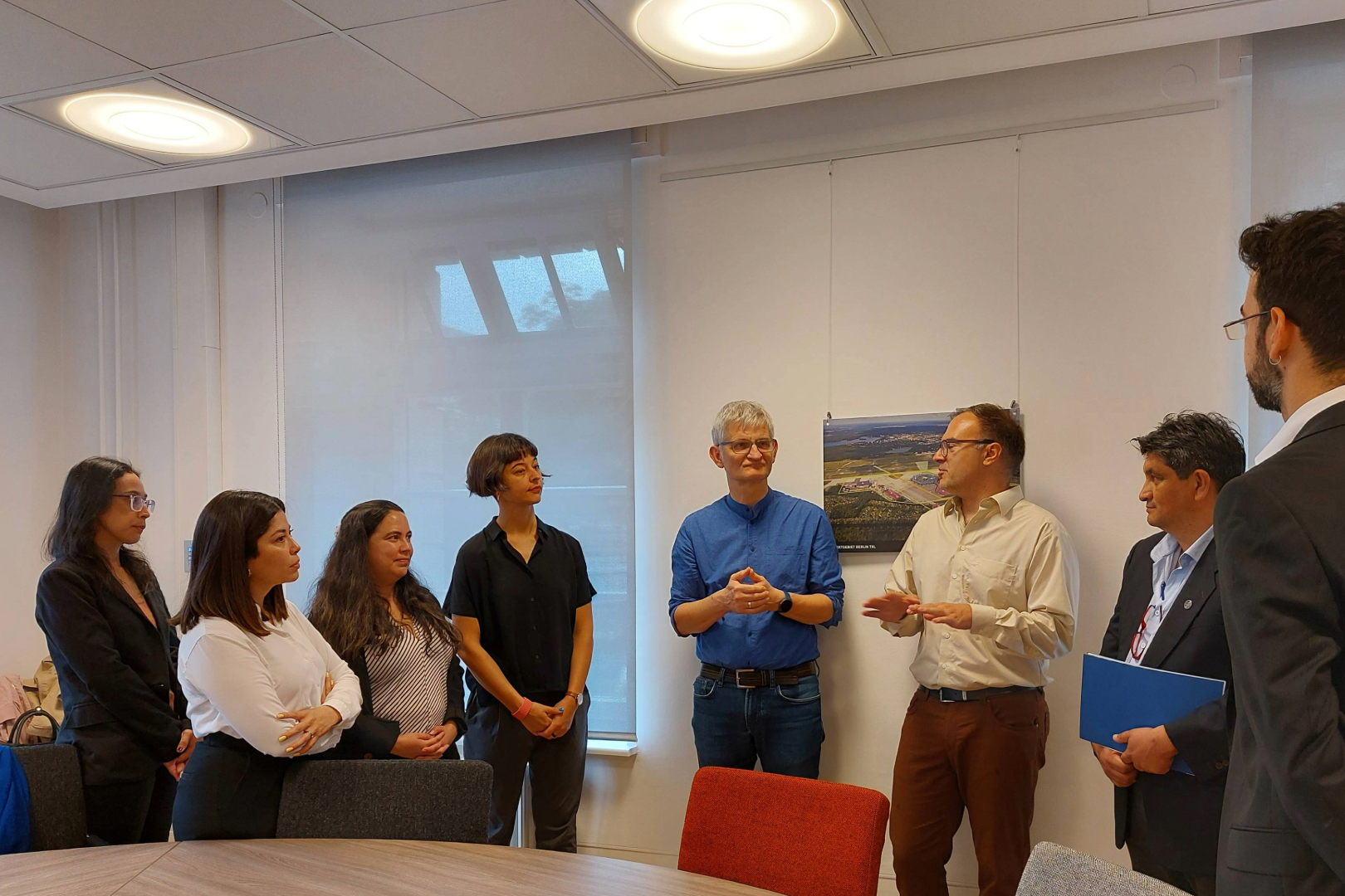 Eine Gruppe von Menschen steht an einem großen Tisch zusammen