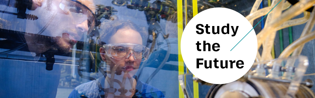 Through a window, a man and a woman wearing safety goggles can be seen looking at the pipes of a process plant. Text: Study the Future.