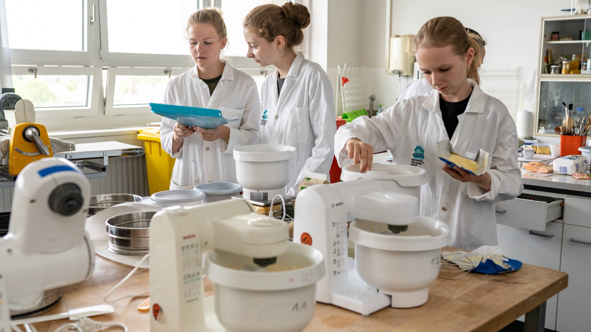Studentinnen an Teig-Rührgeräten im Back-Labor