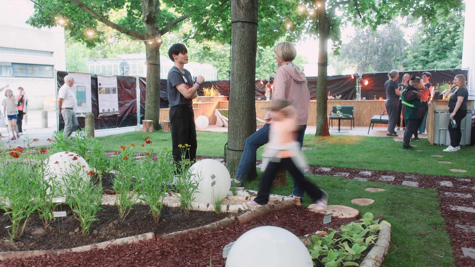 Menschen erkunden angelegte Beete, Wege und Rasenflächen