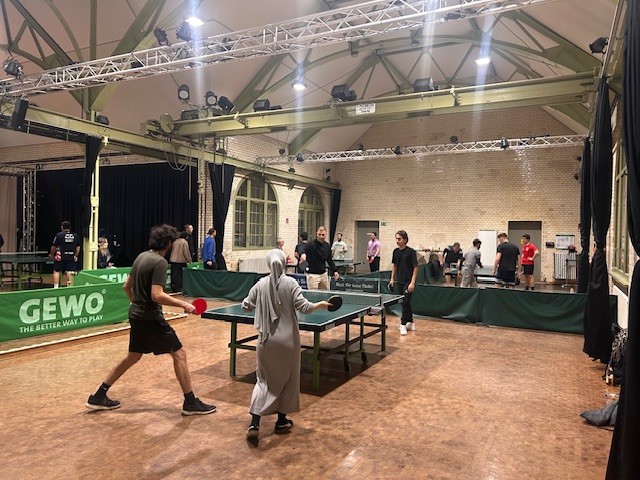 Spieler*innen an einer Tischtennisplatte beim BHT Tischtennisturnier in der Beuth Halle.