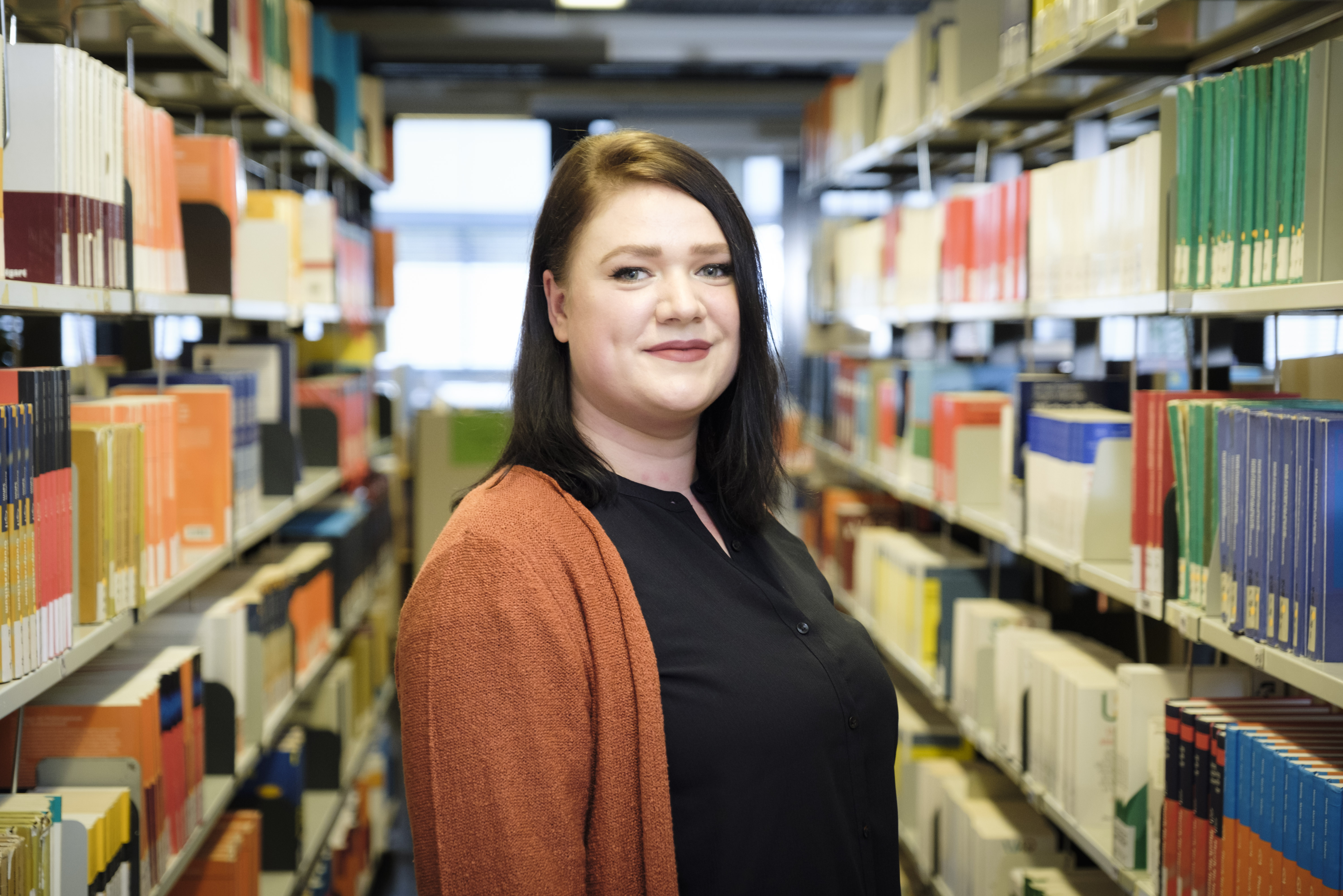 Clarissa Sprenger vor Bücherregalen in der Campusbibliothek