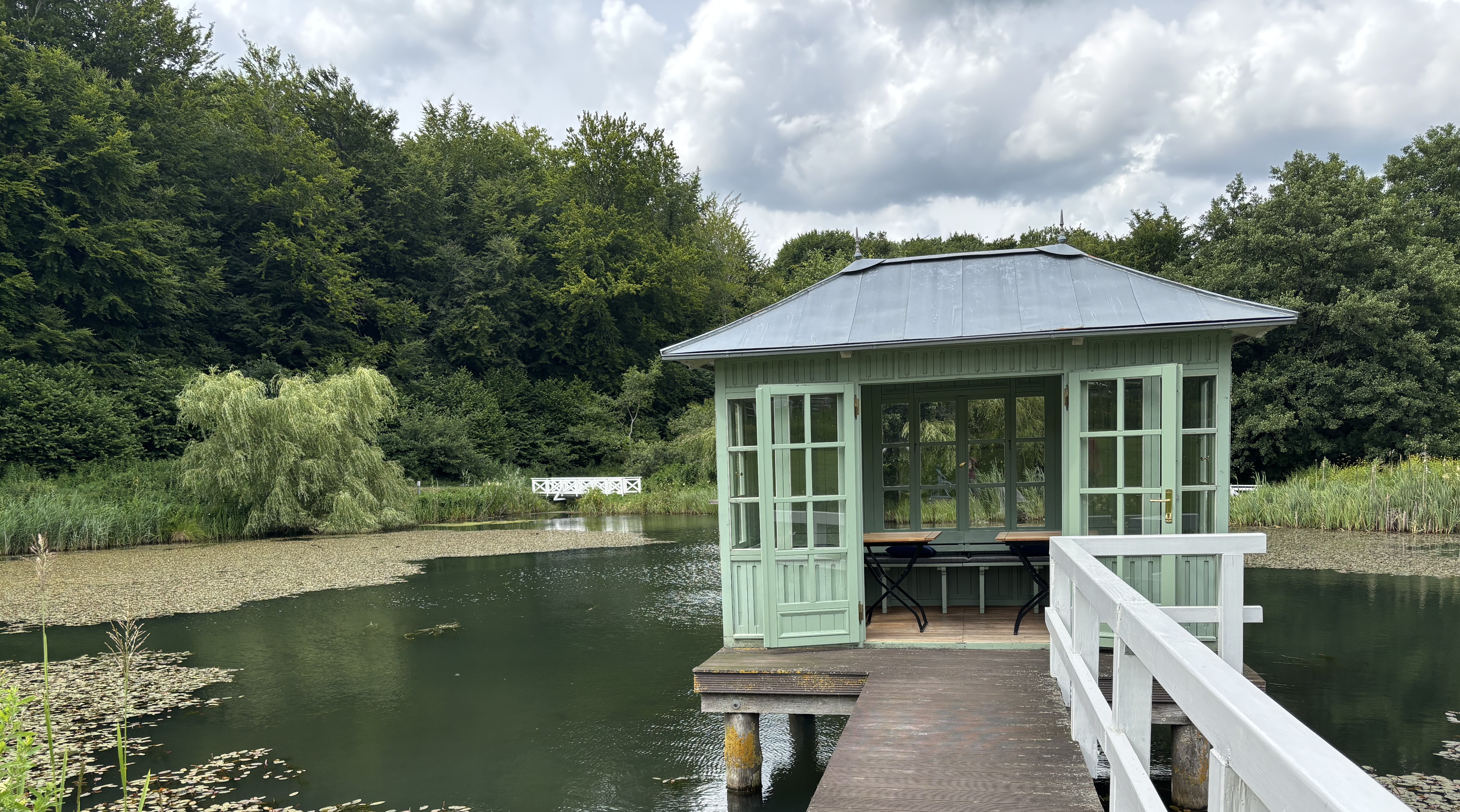 Pavillion auf einem Steg in einem Teich, rundherum Bäume