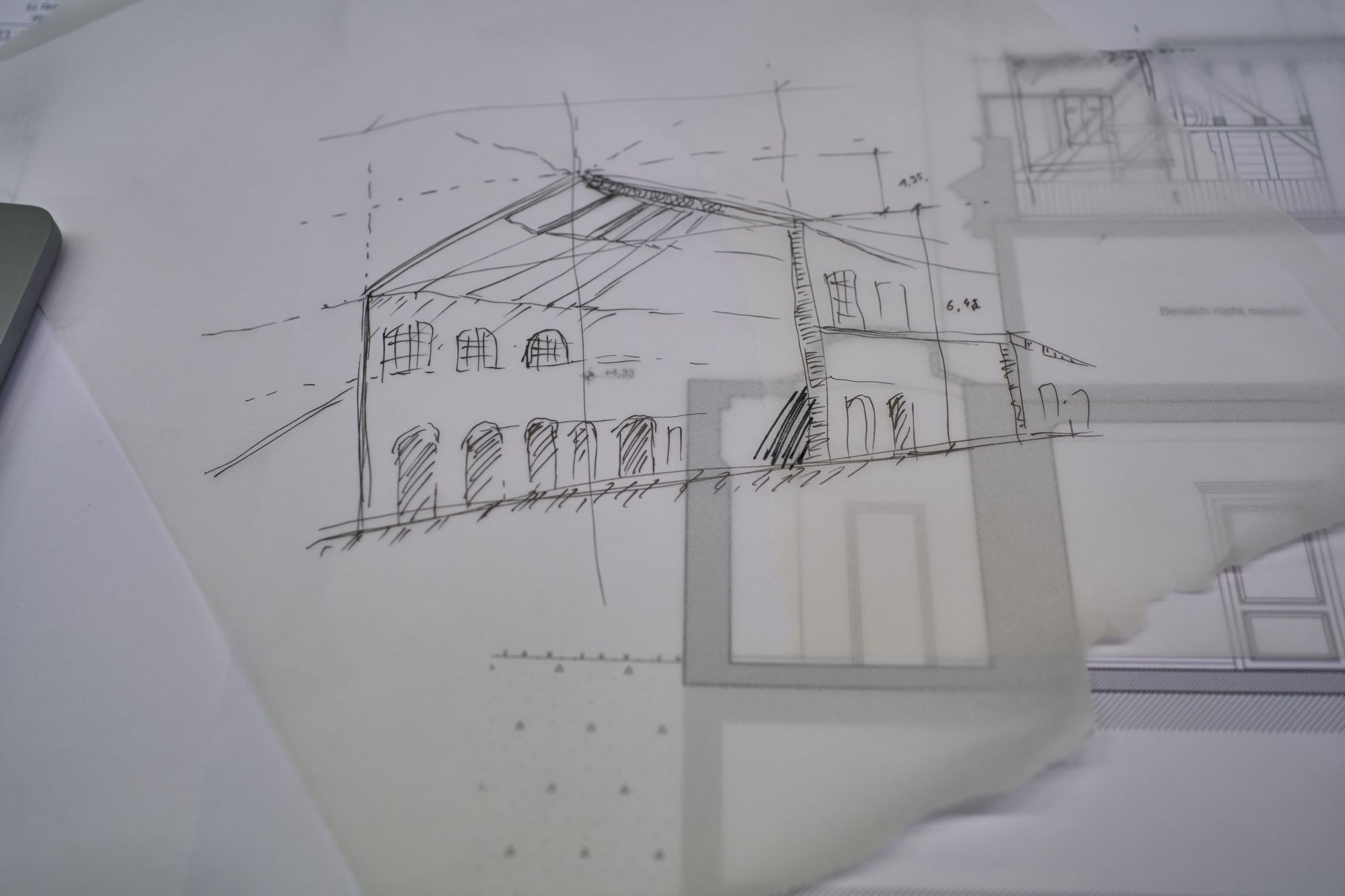 Skizze eines zweistöckigen Gebäudes, schwarzer Stift auf weißem, halbdurchsichtigem Papier.