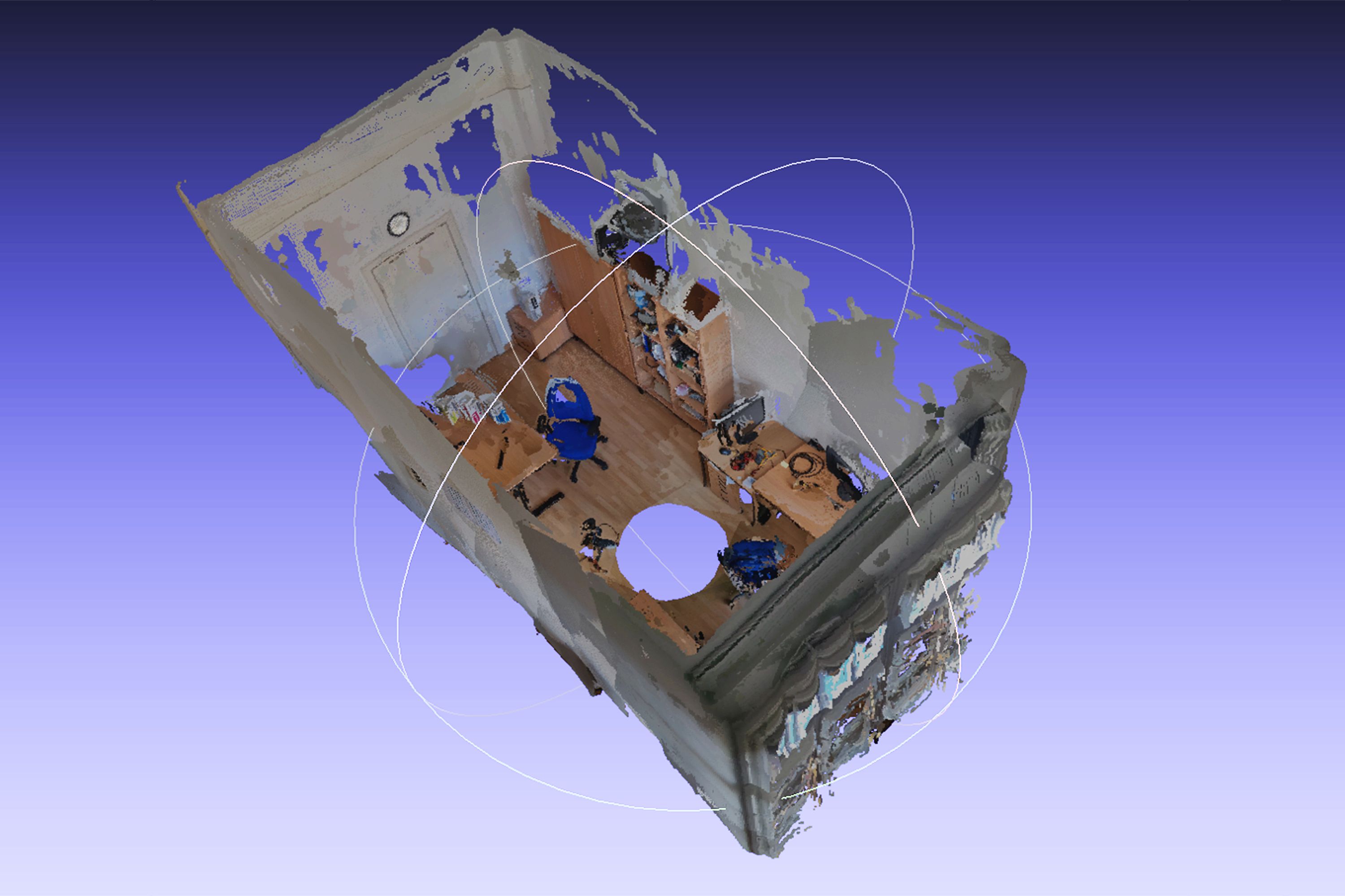 Blick von oben in ein rechteckiges Zimmer, die Tür ist geschlossen. An den Wänden stehen zwei Schreibtische, auf denen Bildschirme stehen und Kabel liegen. Außerdem befinden sich im Raum ein blauer und ein bunter Schreibtischstuhl, zwei offene Regale und ein Wandschrank.