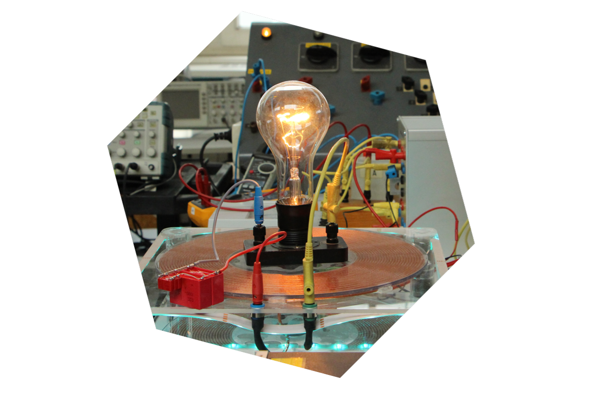 Eine Glühbirne ist in eine schwarze Halterung geschraubt und leuchtet, drum herum rote, gelbe und blaue Kabel