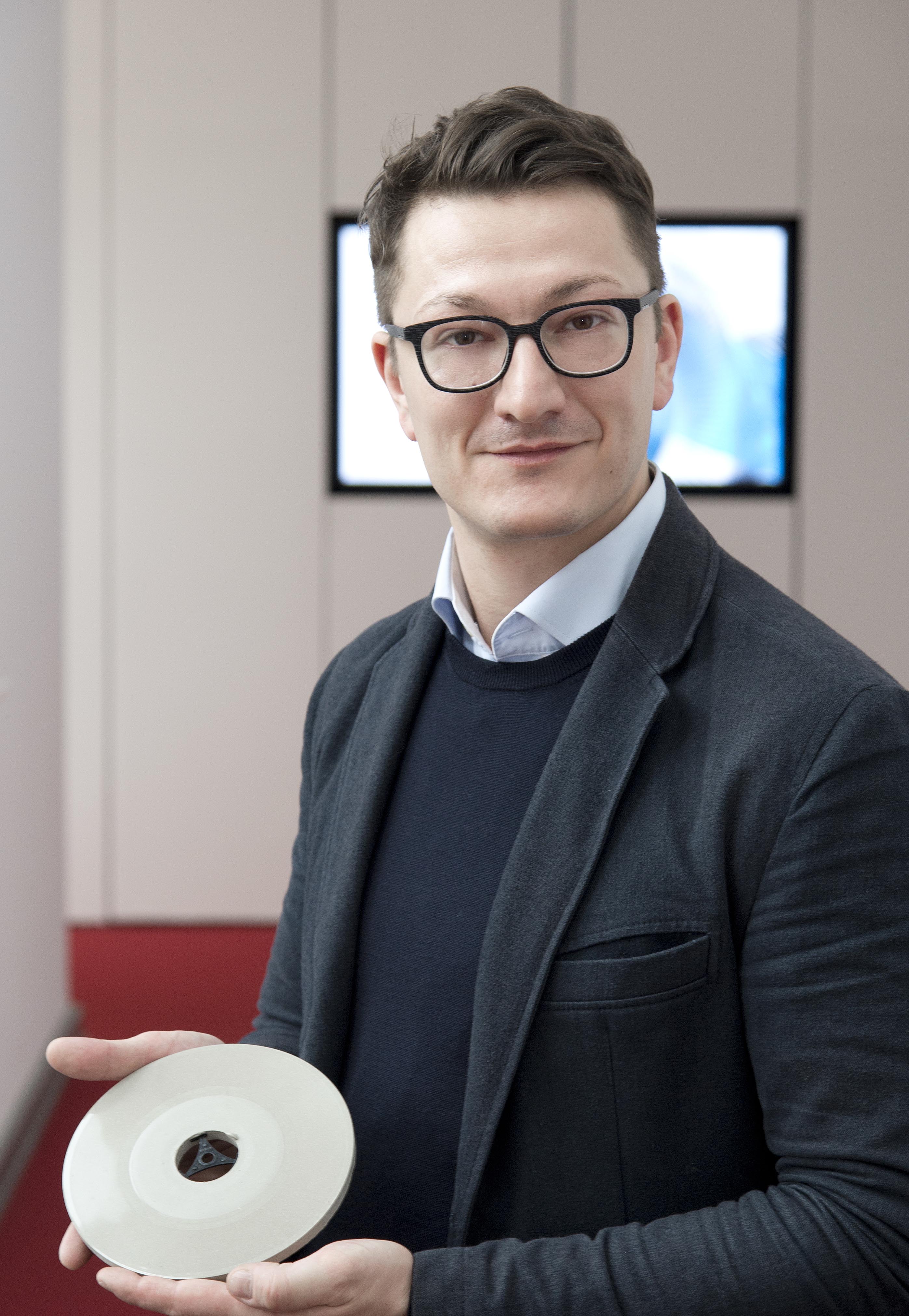 Ricardo Kocadag mit einer Schallplatte aus Ultrahochleistungsbeton (Foto: Bundesanstalt für Materialforschung und -prüfung (BAM))