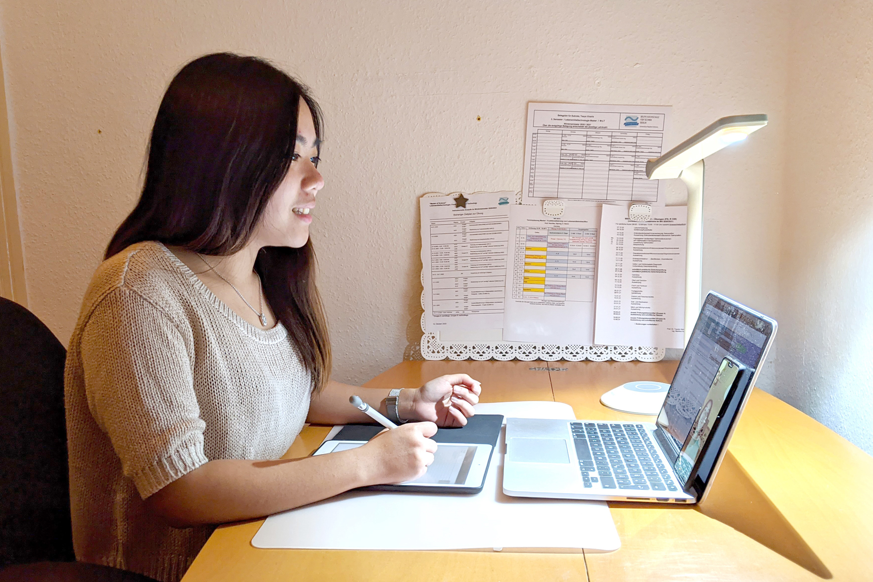 Studentin Tasya Subrata sitzt am Schreibtisch vor dem Laptop